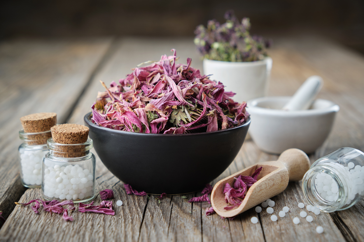 Bottles of Homeopathic Globules and Cornflowers in a Bowl